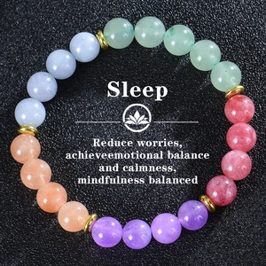 Detail of amethyst and turquoise beaded bracelet with gold spacers on a black background