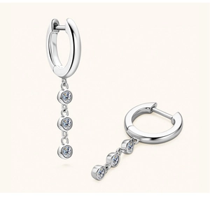 Detail view of silver tassel earrings with three round-cut moissanite stones and clasp