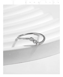Detail of s925 silver wave ring featuring three sparkling round moissanite stones
