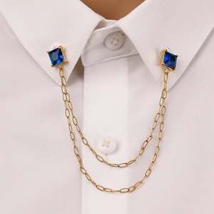 Gold chain collar pin with square blue zircon stones on a white shirt collar
