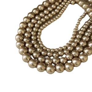 Elegant multi-layer gold pearl necklace with gradient beads on white background