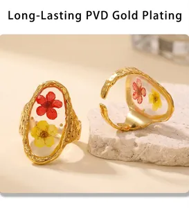 Macro view of gold PVD plated rings featuring resin-encapsulated colorful dried flowers