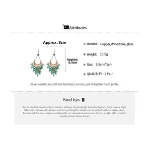Detailed view of luxury tassel earrings with green crystal droplets and silver needles