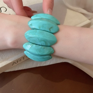 Detailed macro view of mint green marble textured acrylic stretch bracelet on a wrist