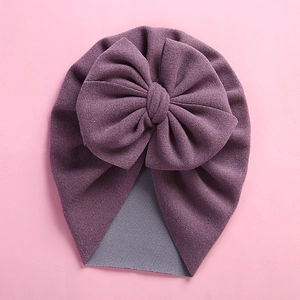 Detailed view of soft purple baby turban hat with oversized bow and gray lining