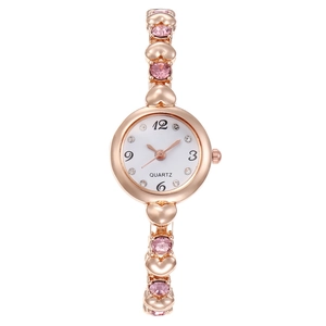 Women's rose gold heart-link bracelet watch with pink stones and a white quartz dial