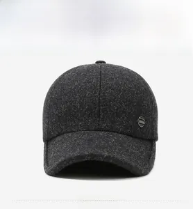 Detail of dark grey wool baseball cap showing thick plush texture and metal fashion badge