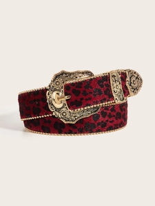 Macro detail of red leopard print belt with vintage engraved gold buckle and bead edges