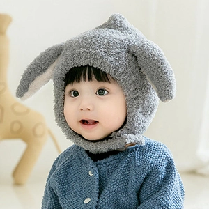 Close-up of baby wearing a soft grey plush rabbit ear hat with warm ear flaps