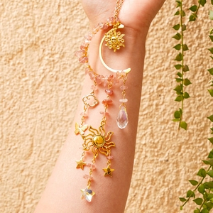 Detail of sun and moon crystal suncatcher featuring pink stones and drop pendant
