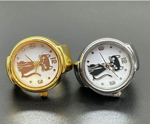 Macro detail of gold and silver cat-themed finger watch rings with cat silhouette dials