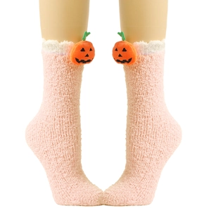 Detail von rosa Plüsch-Korallenvlies-Socken mit 3D-Kürbis-Dekor und weißem Kunstfellbesatz