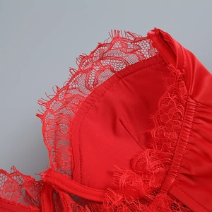 Détail macro de la bordure en dentelle rouge et de la doublure en satin lisse de la robe
