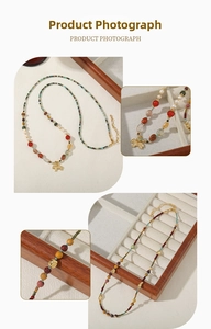 Detail view of multi-color beads, freshwater pearls, and golden animal charm necklace