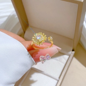 Detail of adjustable gold sunflower ring with sparkling cubic zirconia on a gift box