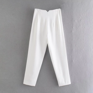 Detail of white trousers featuring a unique V-cut high waistband and pleated design