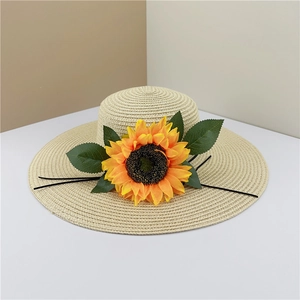 Détail du chapeau de paille avec tournesol montrant la texture tissée et l'ornement