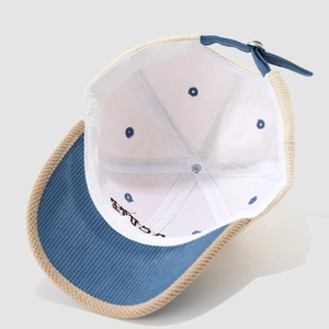 Detail view of corduroy lining and metal buckle adjustment on striped kids baseball cap