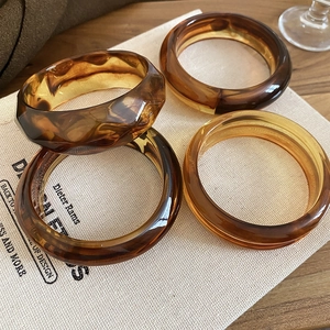 Detailed view of four amber resin bracelets with geometric facets and tortoiseshell patterns