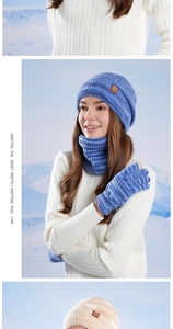 Close-up of blue and white knit winter set featuring thick cable textures and leather logo