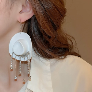 Detail of white cowboy hat earring with sparkling rhinestone fringe tassels on a model