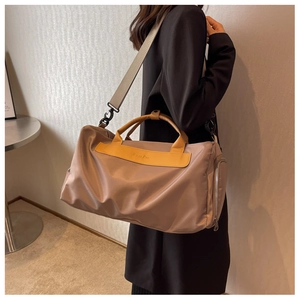 Woman carrying khaki large capacity yoga travel bag with yellow leather trim and strap