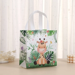 Detail of non-woven gift bag featuring a cute cartoon giraffe and tropical leaf print
