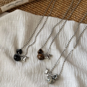 Three minimalist necklaces with tiger eye stones and puppy charms on white fabric