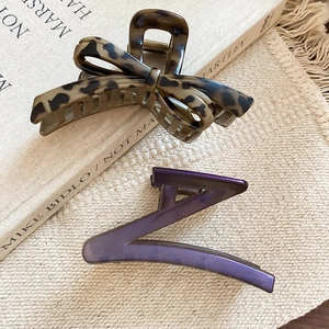 Detailed macro view of leopard print hair claw and purple metallic Z-shaped clip