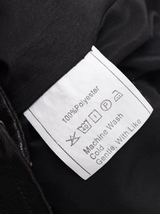 Gros plan de l'étiquette d'entretien montrant 100% polyester et conseils de lavage