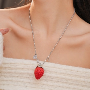 Dettaglio del ciondolo a fragola in resina rossa con zircone su catena a sfere argento