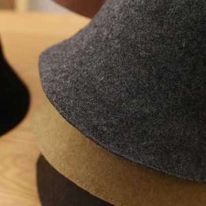 Macro shot showing premium wool felt texture and precise stitching on several bucket hats