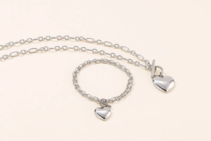 Detailansicht von silbernem Herzanhänger-Halskette und Armband-Set mit T-Verschluss