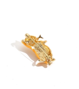 Close-up of the golden metal back and safety pin clasp of the orange cat brooch