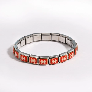 Detail of Italian charm bracelet links with red enamel and white geometric pattern
