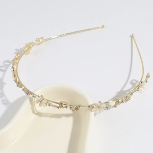 Detail of golden headband with white enamel flowers and sparkling rhinestones close-up