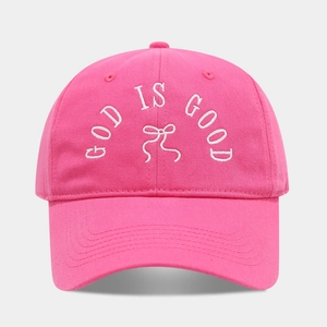 Pink cotton baseball cap featuring embroidered white text and bow on a curved brim hat