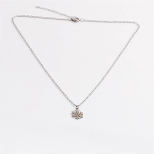 Polished stainless steel snowflake pendant necklace with silver link chain on white background