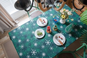 Détail de la nappe de Noël vert foncé avec motifs de flocons de neige blancs et texture