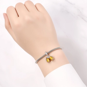 Silver snake chain bracelet featuring two yellow enamel beer mug charms on marble