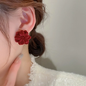 Close-up of elegant red flocked flower earrings on a model for a vintage French aesthetic