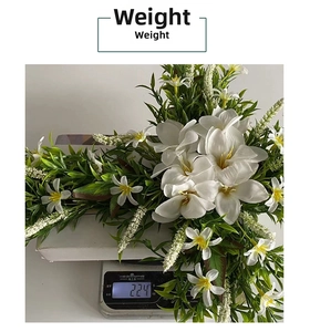 Detail shot of white cross lily Easter wreath on a scale showing a weight of 224g