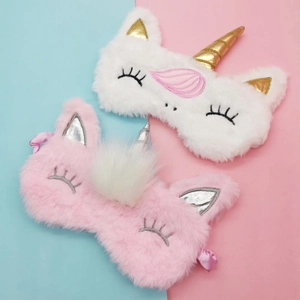 Unicorn plush sleep masks in pink and white with golden horns and soft fur textures