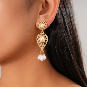 Vintage hollow flower pearl earrings with golden tassels and metal drop design