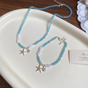 Parure bijoux thème océan avec perles bleues, pendentifs étoile de mer et coquillage argentés