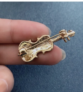 Macro shot of the back pin fastener and golden metal violin brooch structure