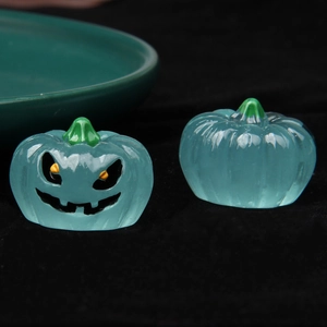 Macro shot of luminous blue translucent pumpkin figurines for Halloween DIY decor