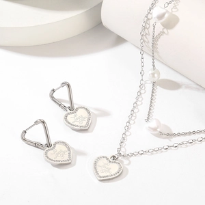 Detail of silver heart jewelry set with Love You engraving and sparkling rhinestones