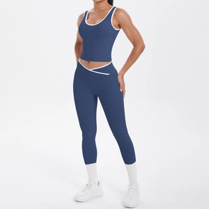 Detail of high waist V-cross leggings and blue sports bra with white contrast piping