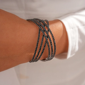 Close-up of black geometric multi-layer cross bracelet with sparkling pavé rhinestones